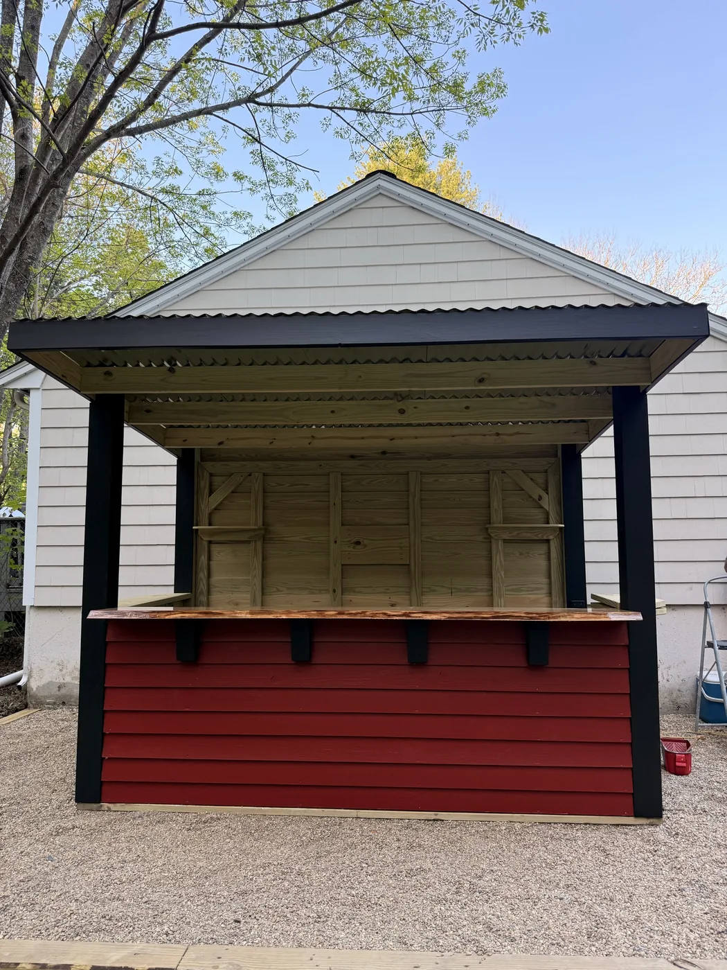 Finished custom outdoor bar in Pembroke with red panels and black trim